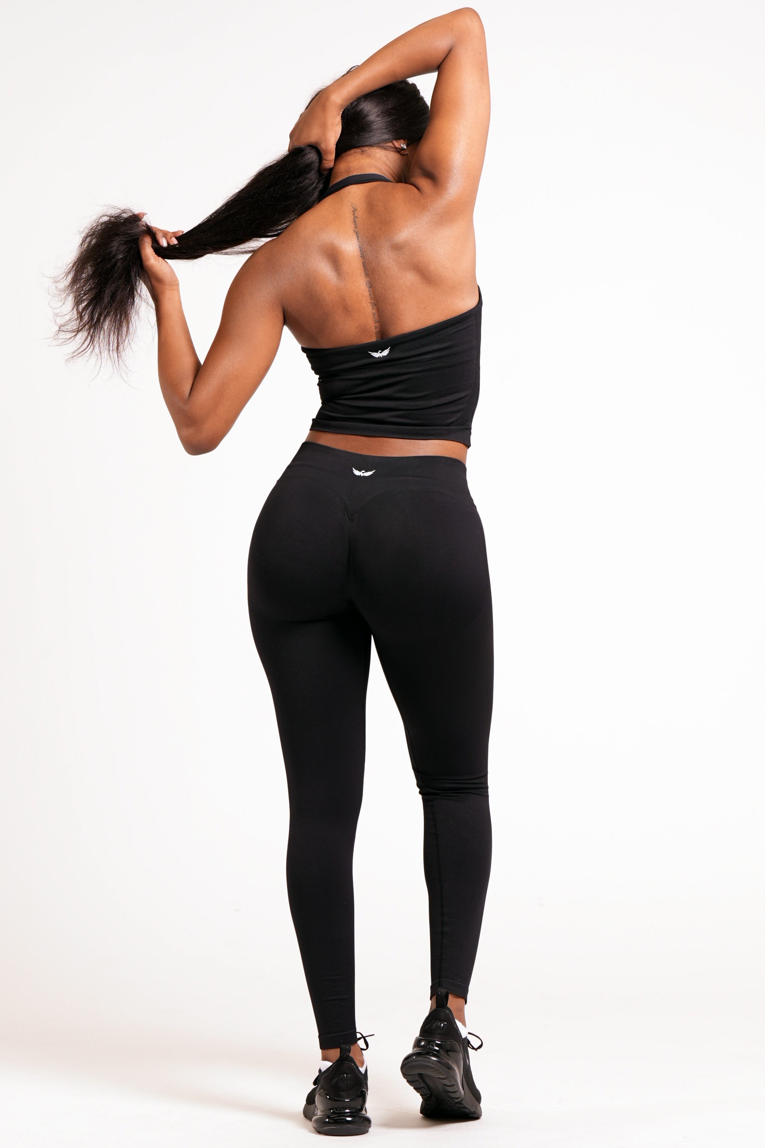 Woman wearing black leggings on a white background